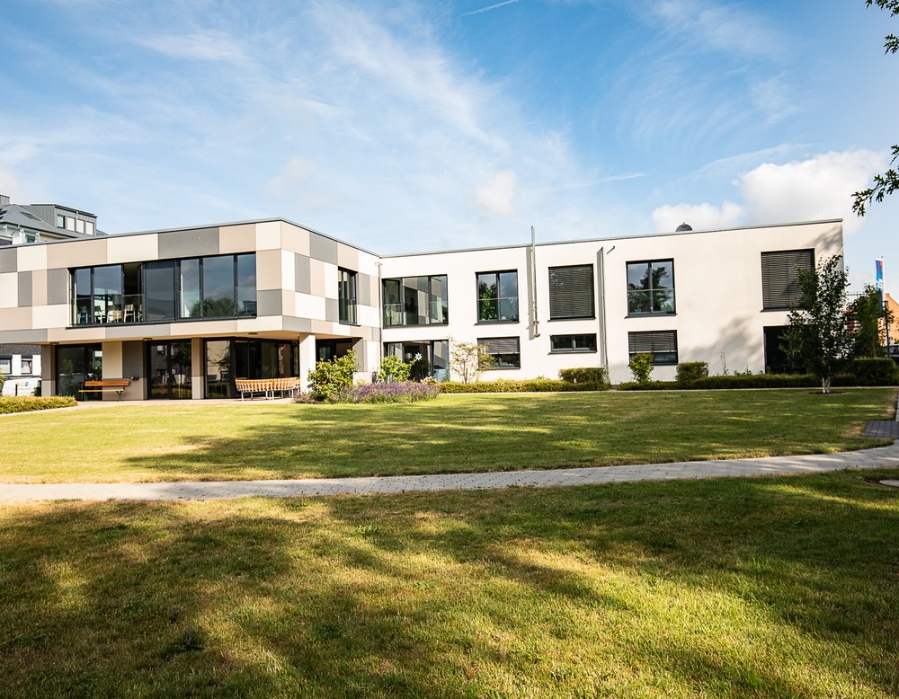 Blick auf Rasenfläche und das moderne Gebäude der Tagesklinik in Salzkotten