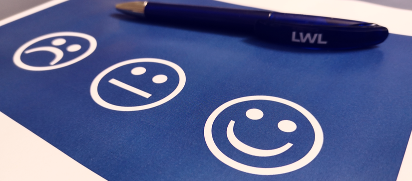 Smiles und Stift auf blauem Hintergrund