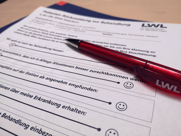 Fragebogen der LWL-Befragung und roter Kugelschreiber mit Aufschrift LWL